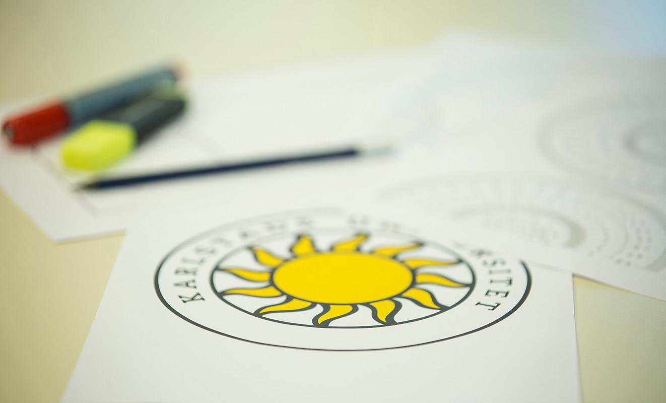 Pennor och papper ett blad med Karlstads universitets logo