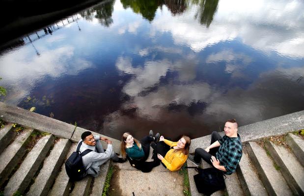 Foto uppifrån på fyra studenter med blicken mot kameran i kajtrappa vid Klarälven