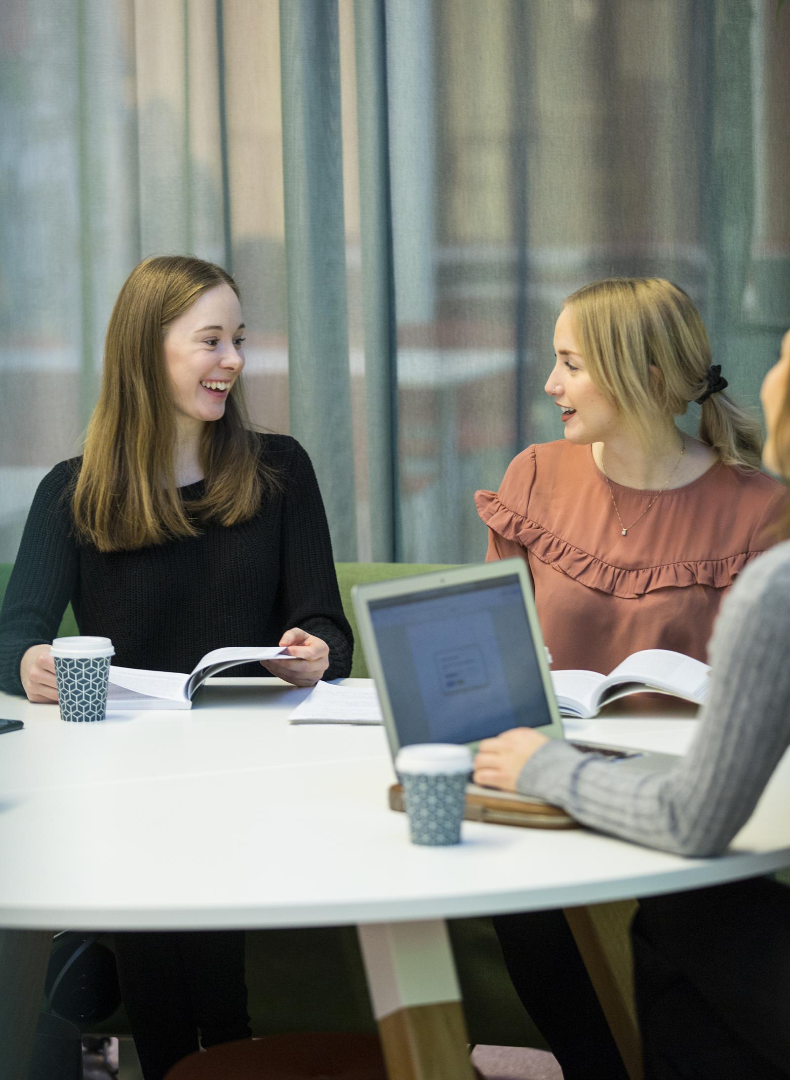 Två glada studenter som pratar i Café Gläntan