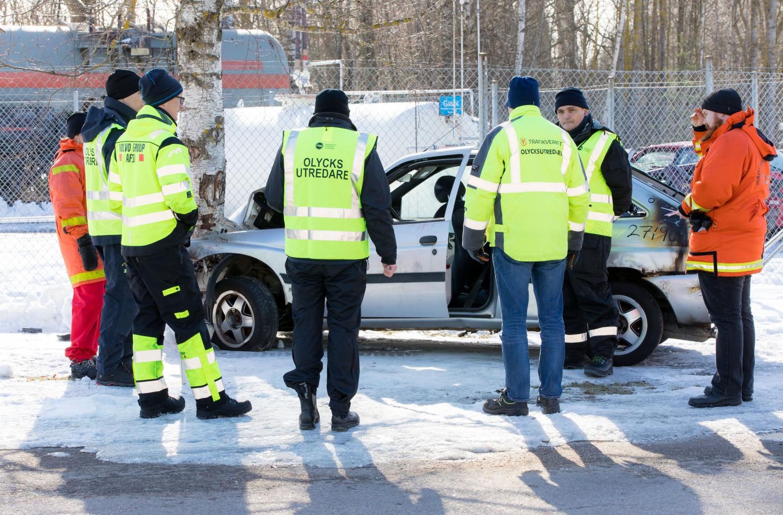 Personer vid en olycksskadad bil