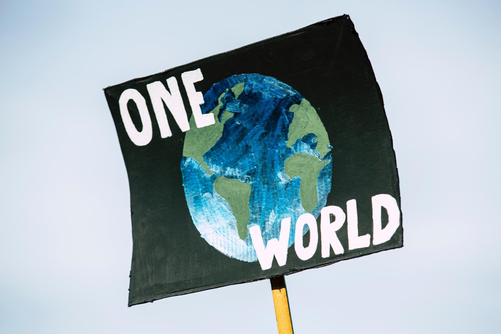 Plakat med en jordglob och texten one world