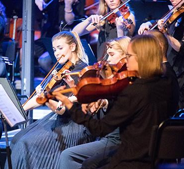 Unga kvinnor spelar violin