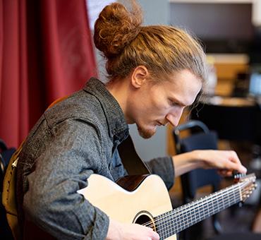 Student stämmer sin gitarr