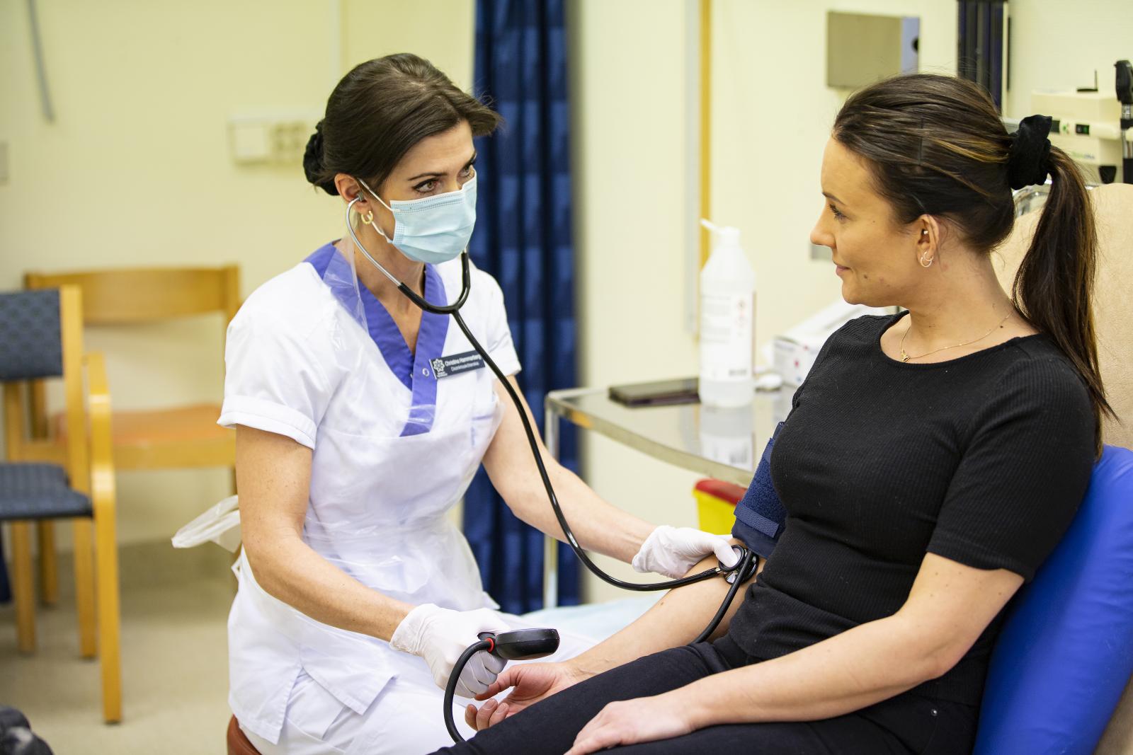 Sköterska tar blodtryck på patient
