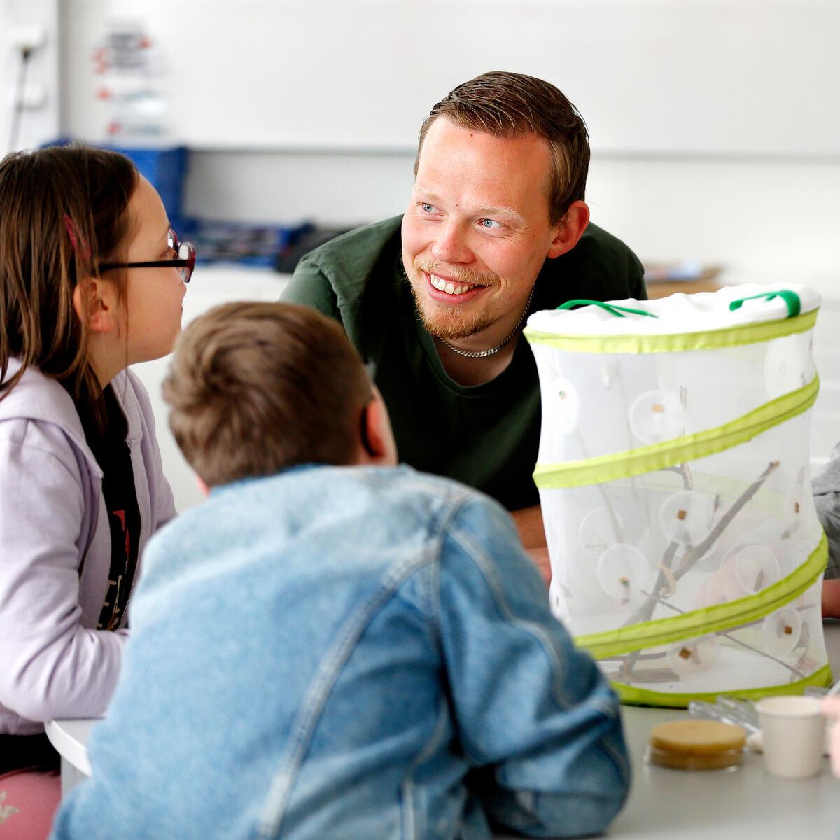 Lärare i samtal med elever i klassrum