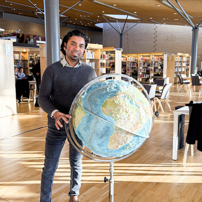 Avit Bhowmik stående vid jordglob