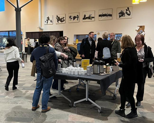 Personer som minglar runt ett fikabord vid CRS symposium