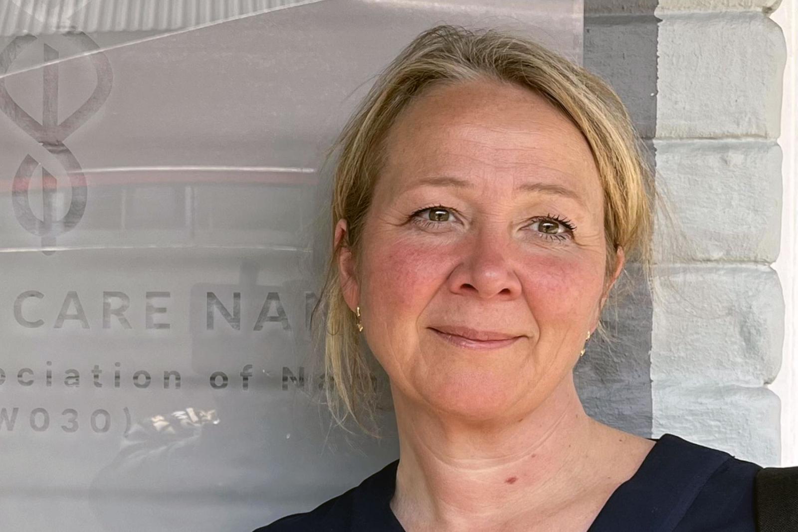 Kvinna står framför grå bakgrund 
