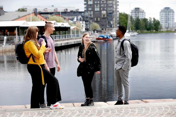 Fyra studenter väntar på en båtbuss i inre hamn, Karlstad centrum