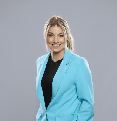 Leende blond kvinna i blå kavaj