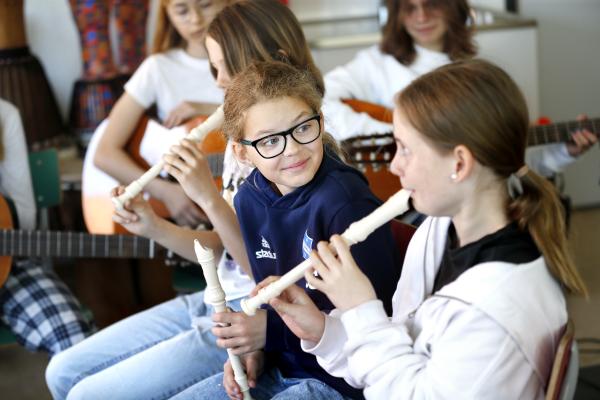 Elever spelar blockflöjt i klassrummet