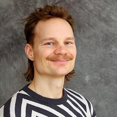 Leende man med mustasch iklädd randig tröja