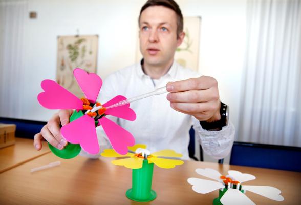 Peter Lampert demonstrerar färgglada modeller på ett bord.