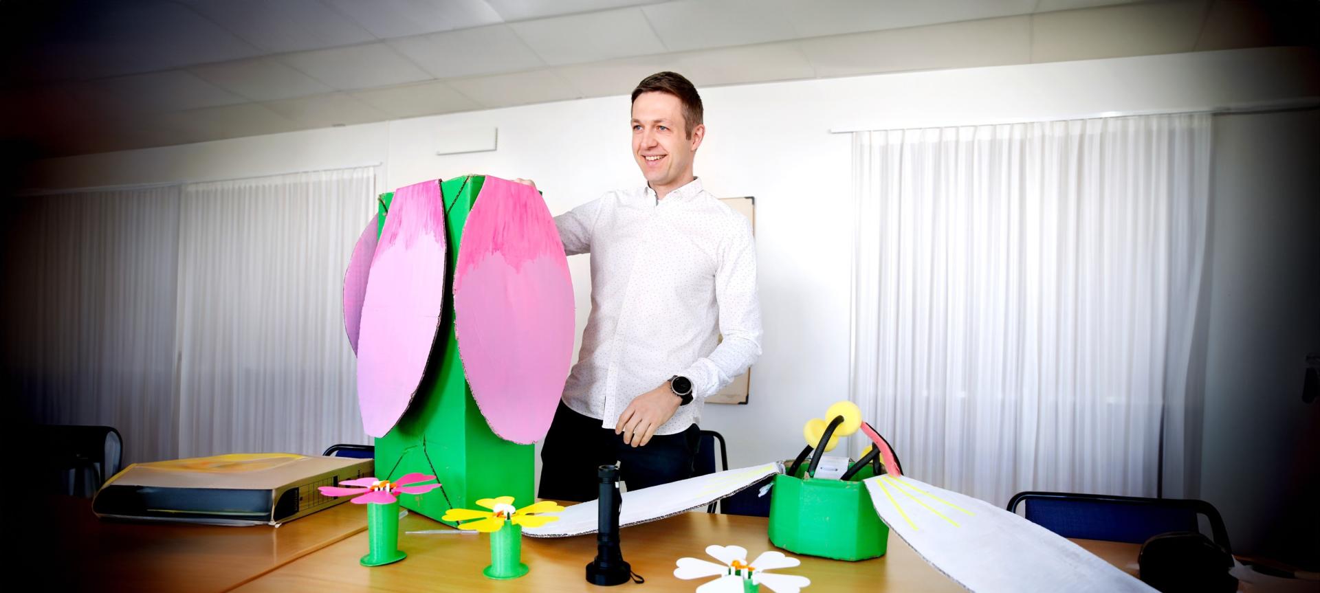 Peter Lampert demonstrerar färgglada modeller på ett bord.
