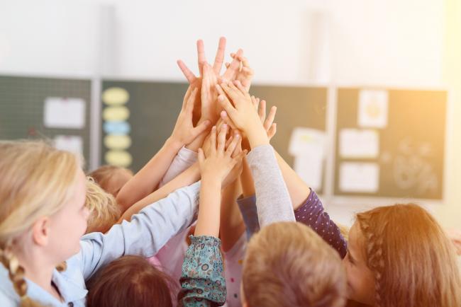 Barn gör high-five i klassrum