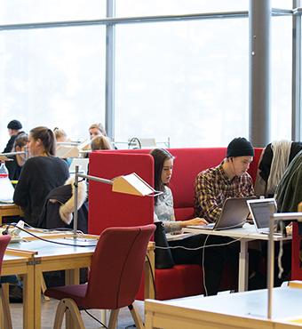 studenter vid studieplatser i biblioteket