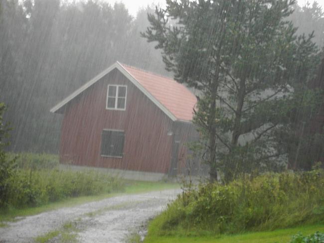 Raining over a red wooden house