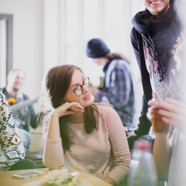 Studenter diskuterar vid fikabord