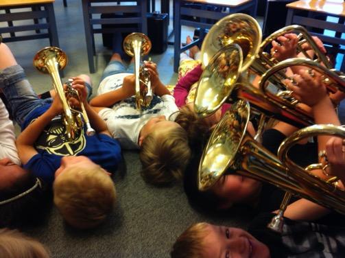 Barn som ligger på golvet och spelar blåsinstrument