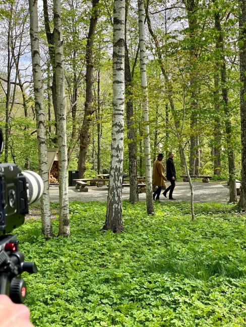 filmkamera i lövskog med två personer