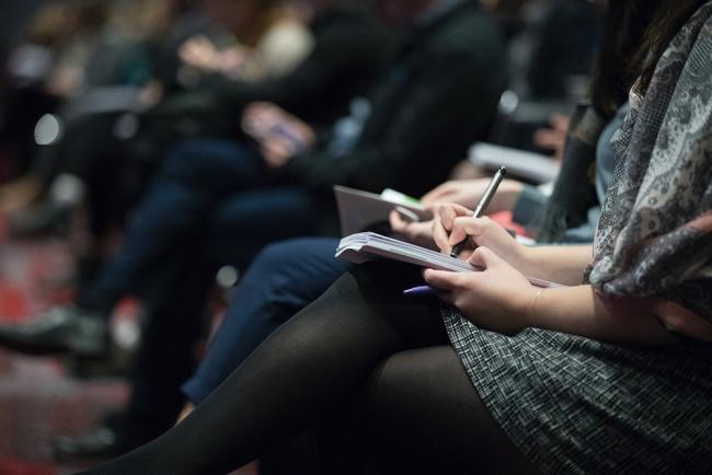 Kvinna gör anteckningar på en konferens