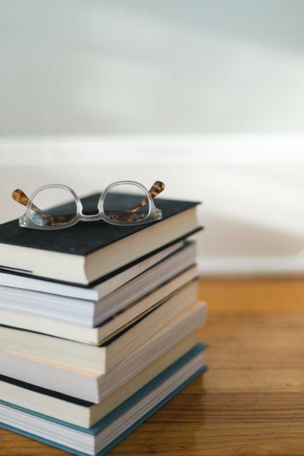 Glasögon som vilar på en trave böcker