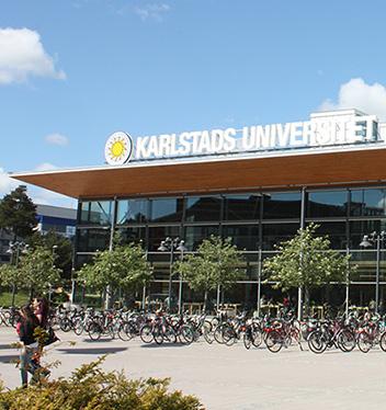 Universitetsbibliotekets fasad med grönskande träd framför