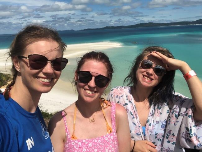 Tre studenter vid en strand