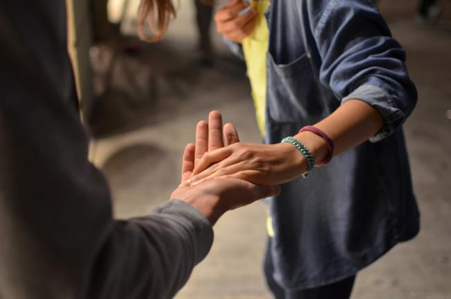 Två personer i rörelse som håller varandra i hand.