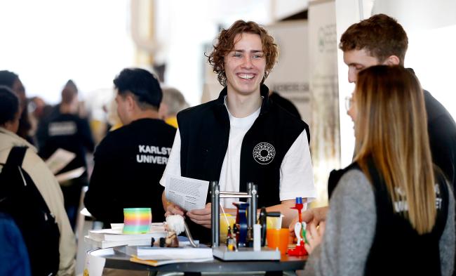 leende student i samtal med två kompisar