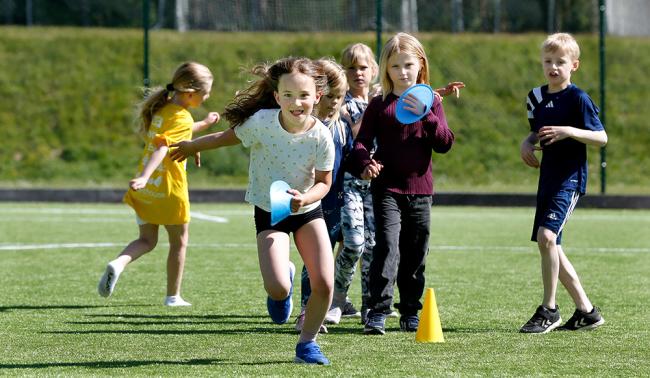 Barn idrottar på en fotbollsplan