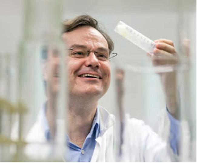 man looking at a test tube