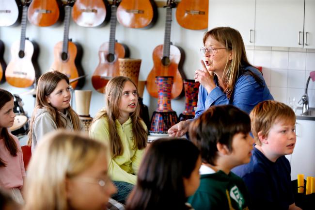 Musikundervisning med gitarrer i bakgrunden