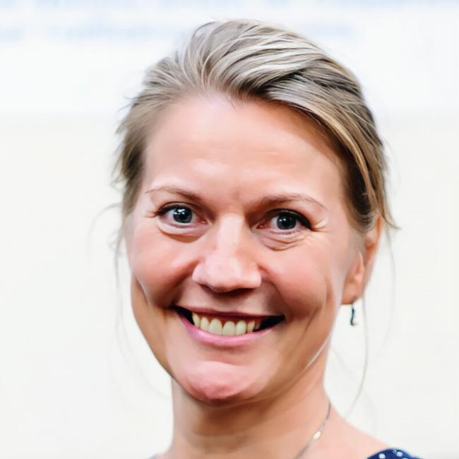 porträttbild av kvinna med uppsatt hår som ler