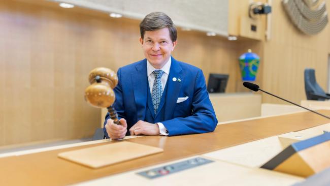 bild på man med ordförandeklubba inomhus