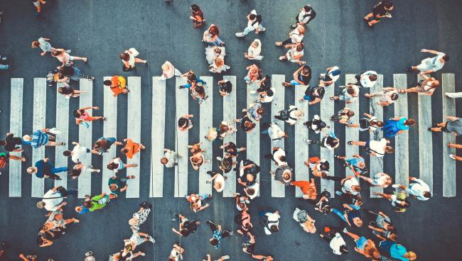 Människor som går över ett övergångsställe sett ovanifrån.