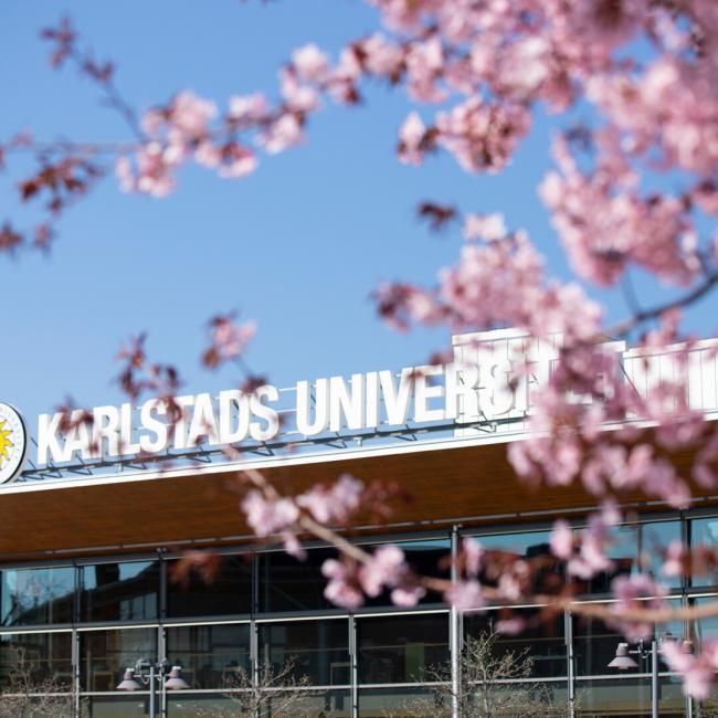 blommande kvist framför skylt på byggnad utomhus