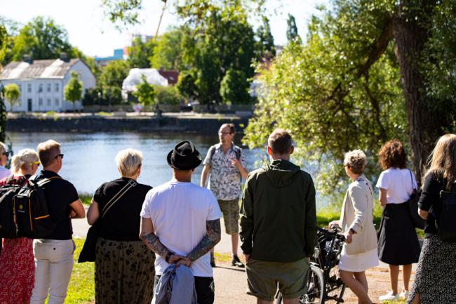 folk står och lyssnar på en man vid klarälven