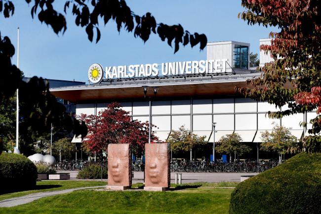 Bibliotekshuset i bakgrunden och konstverken med ansikten i förgrunden