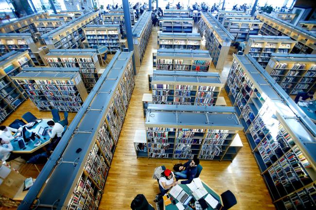 Översiktsbild från biblioteket med bokhyllor och studenter