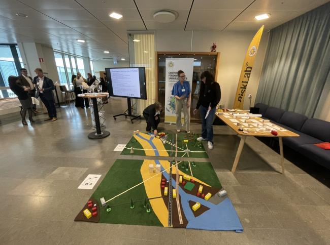 People standing indoors looking at a game on the floor.