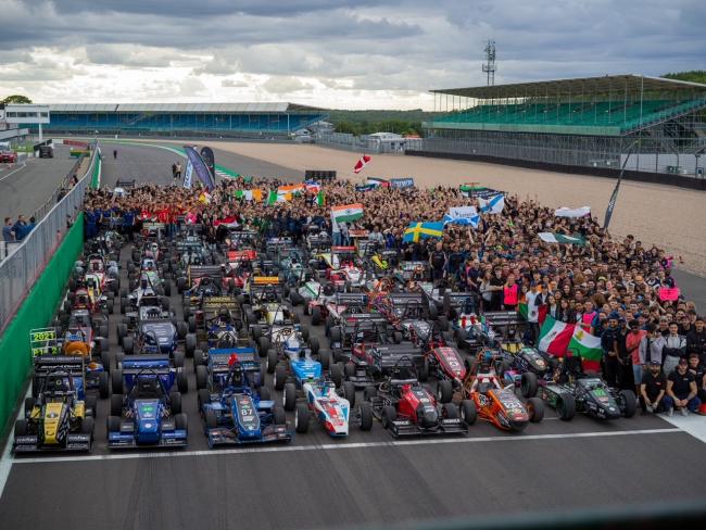 Bilar och studenter på racingbana med flaggor