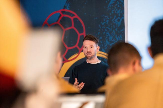 Man som pratar inför publik_James Vaughan_affilierad forskare vid Nationellt forskningscentrum för barn- och ungdomsidrott_1