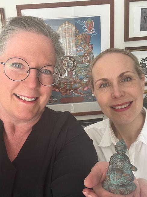 Katarina och Miitra håller i en liten Buddha