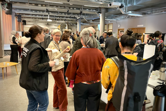 Konferensdeltagare minglar under fikapaus