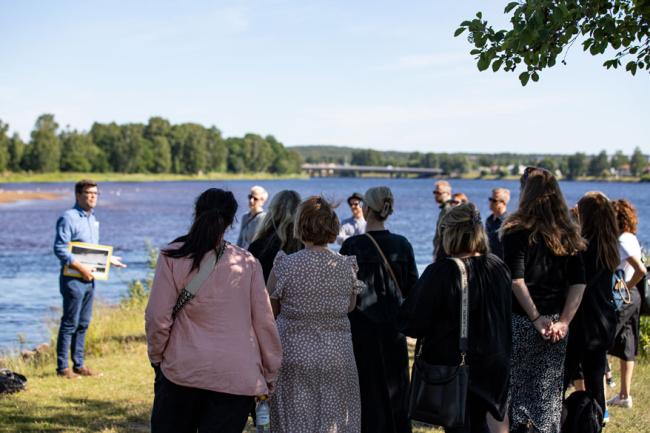 folk står vid en strandkant.