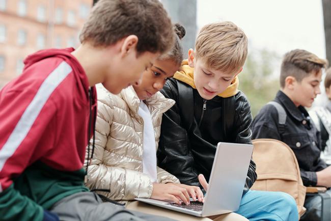 Barn med dator i utemiljö  skola