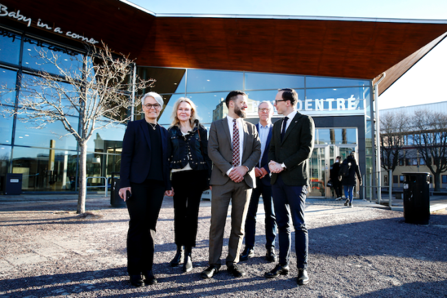 Utbildningsministern och universitetsledningen utanför huvudentrén