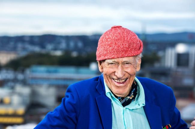 Olav Thon i röd mössa och blå kavaj utomhus