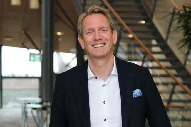Man står inomhus framför trappa